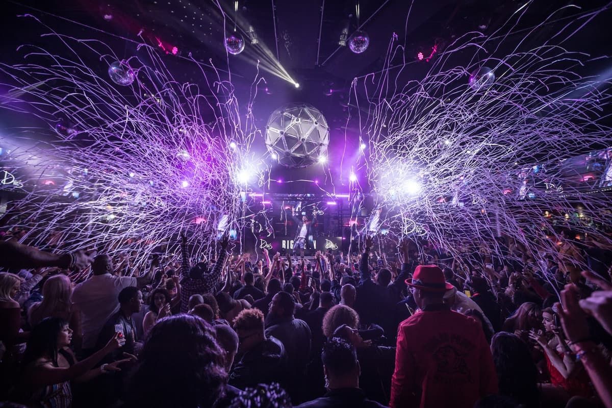 Electrifying club scene in Las Vegas with a crowd enjoying a VIP club tour, featuring dynamic lighting and streamer effects.